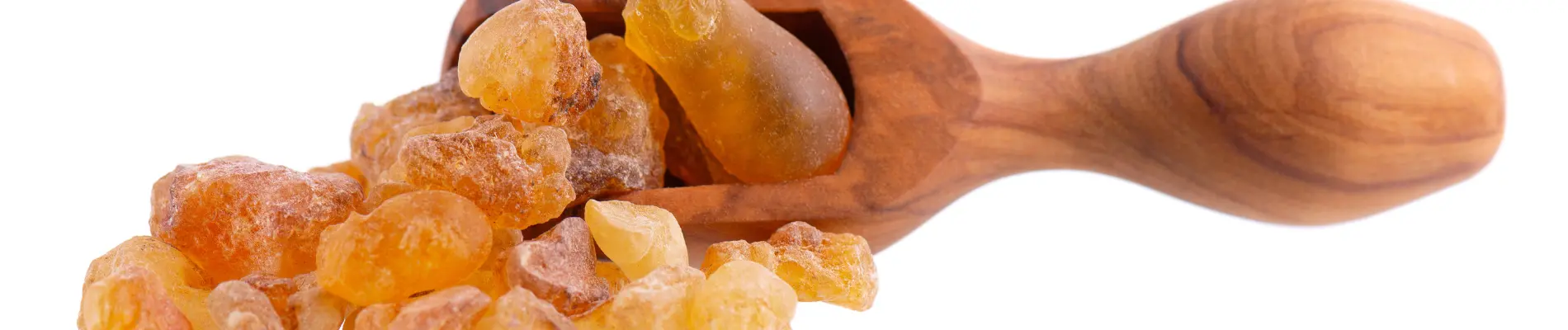 Arabic gum crystals in a polished wooden scoop.