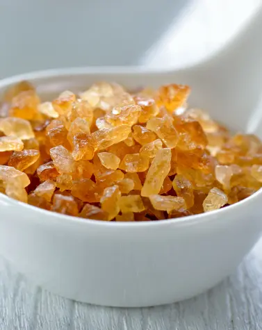 Natural gum crystals in a white bowl, used as food thickeners like guar gum and gum arabic