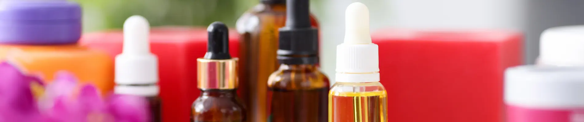 Assorted dropper bottles and cosmetic containers representing natural hair and skin care formulations with cationic guar gum.