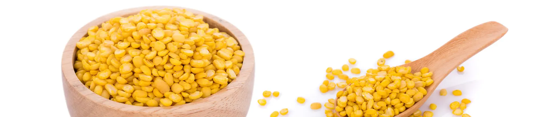 Yellow guar splits in a wooden bowl and spoon on a white background