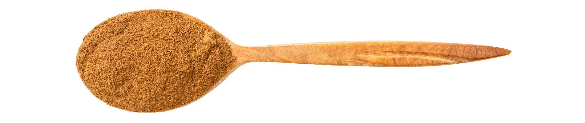 Wooden spoon filled with cassia powder on a white background, showcasing its fine texture and natural color.