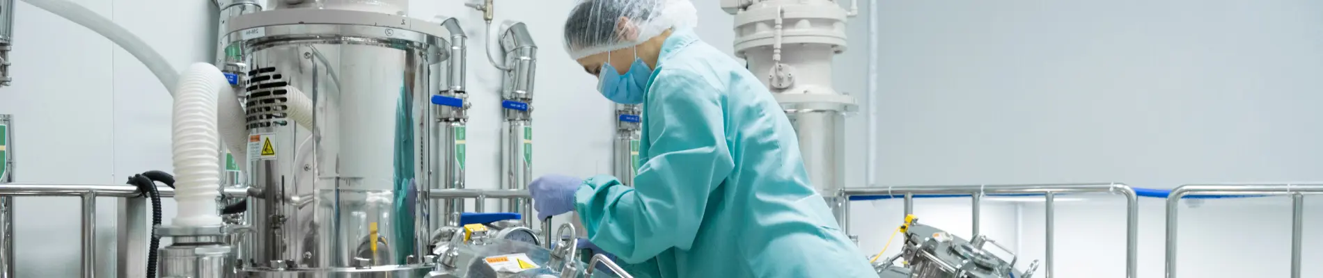 Technician in cleanroom working with stainless steel machinery, representing Sunita Hydrocolloids’ focus on quality control and innovation in food-grade manufacturing.