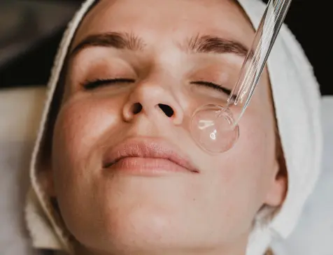 Pipette dropper applying hydrating serum to facial skin for moisture retention and hydration in skincare.