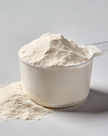 Measuring scoop filled with partially hydrolyzed guar gum powder on a clean background